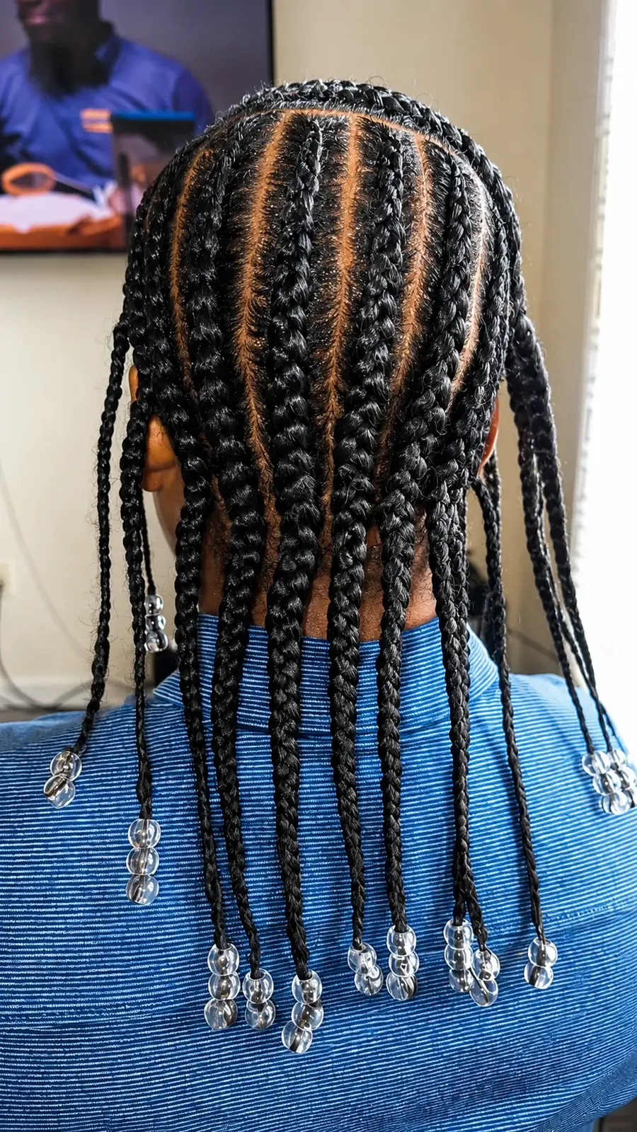 Child's braids parted straight back in even rows with clear beads on the ends, back view