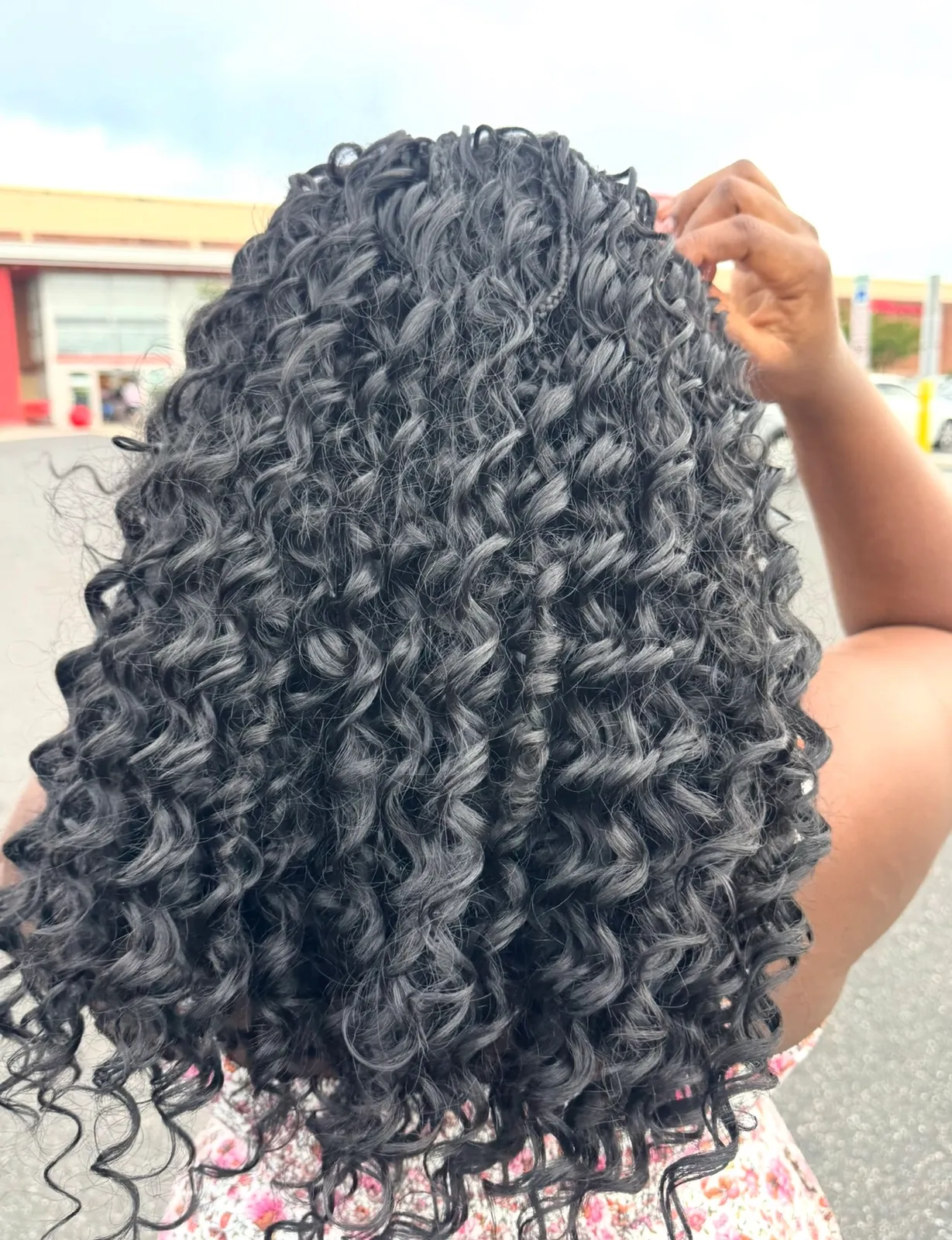 Voluminous defined spiral curls in natural black, back view